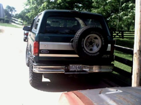 1996 Ford Bronco - This lifted 1996 Ford Bronco features a rear-mounted spare tire and a distinctive two-tone stripe on its side.