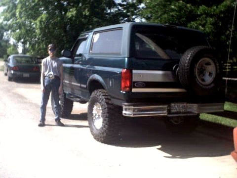 1996 Ford Bronco - Lifted 1996 Ford Bronco with spare tire on the back. A person stands beside the vehicle.