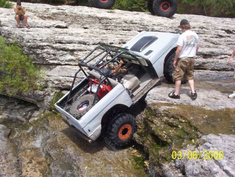 1991 Ford Bronco - 1991 Ford Bronco navigating difficult rocky terrain with a roll cage and extra fuel.