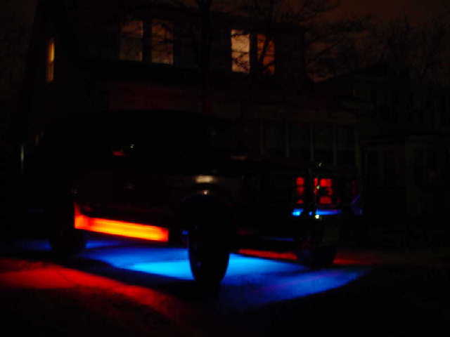 Dark truck with blue and orange underglow lights at night