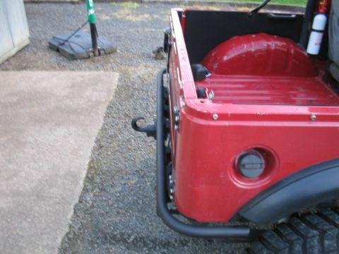 1987 Suzuki Samurai - The rear quarter panel of a red vehicle shows a fuel cap and part of a fender flare.