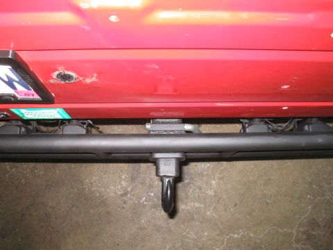1987 Suzuki Samurai - The rear of a red 1987 Suzuki Samurai shows a tow hitch and a license plate bracket.
