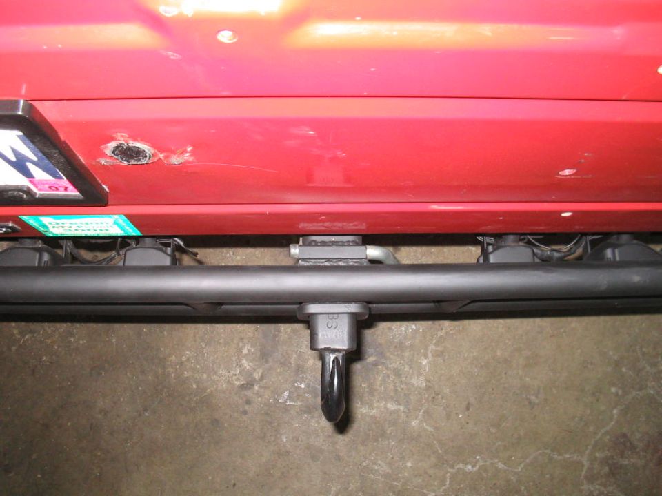 Red 1987 Suzuki Samurai rear bumper with tow hitch and license plate bracket