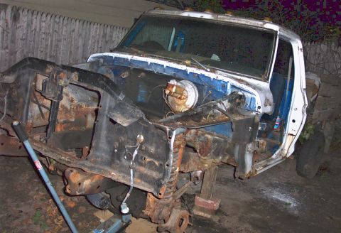 1979 Ford F-150 - The front end of a heavily rusted 1979 Ford F-150 pickup truck, showing its chassis and engine bay components.