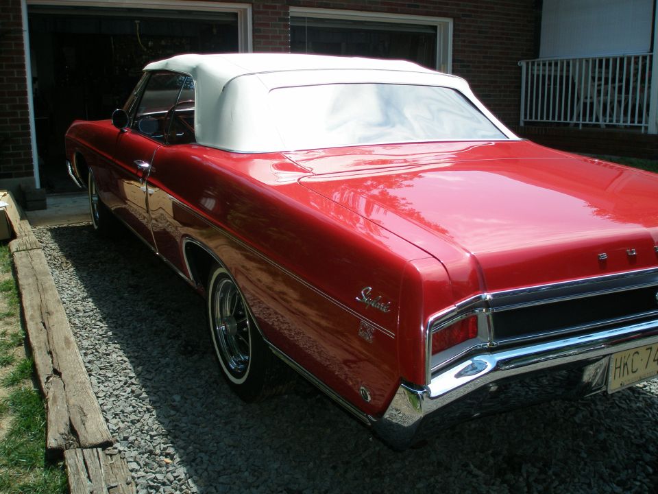 Red Buick Skylark convertible with white top, rear three-quarter view