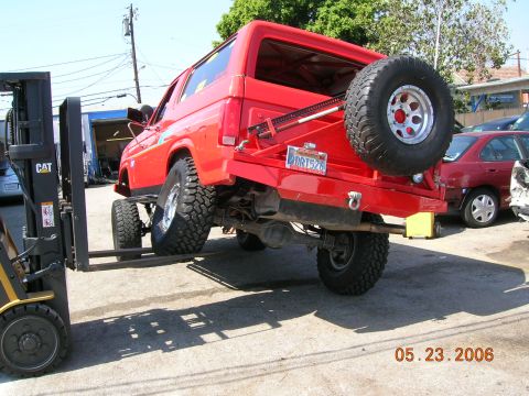 1985 Ford Bronco - 1985 Ford Bronco being moved with a forklift, showing its rear end and spare tire.