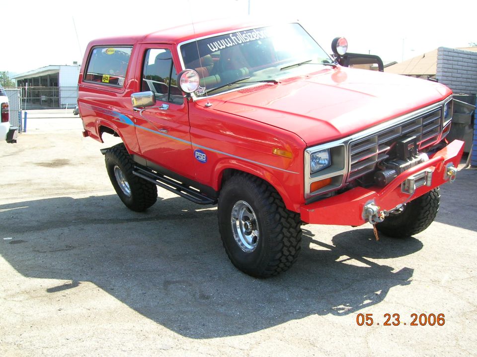 Red lifted Ford Bronco SUV with winch bumper and off-road tires, front 3/4 view