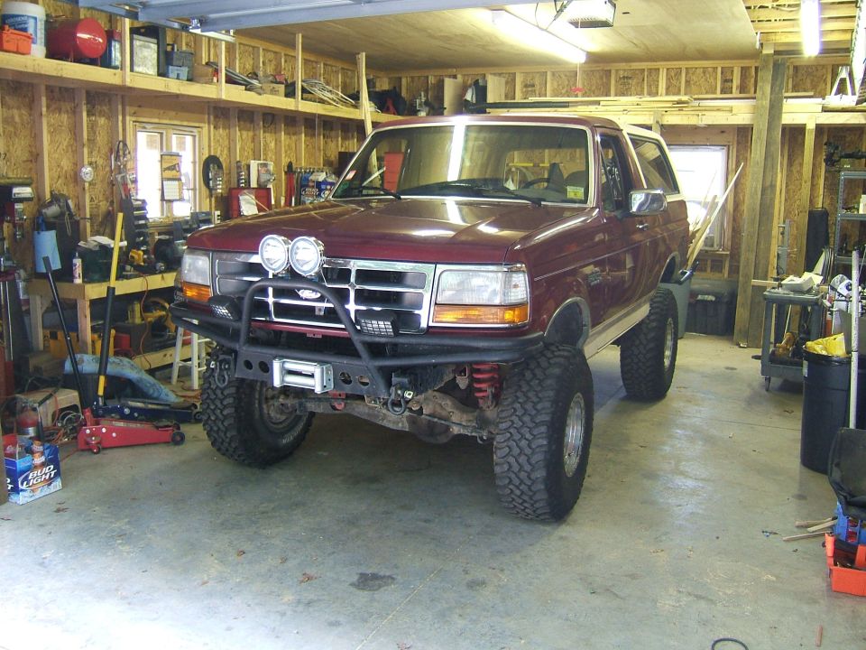 Maroon Ford Bronco in a garage with aftermarket bumper and winch