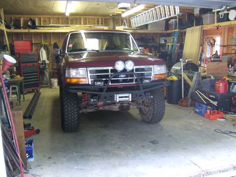 1993 Ford Bronco - A modified Ford Bronco sits in a cluttered garage, ready for off-road adventures.