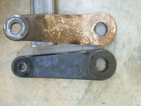 1993 Ford Bronco - Comparison of a rusty and a newly painted steering linkage arm, showing part numbers on the latter.