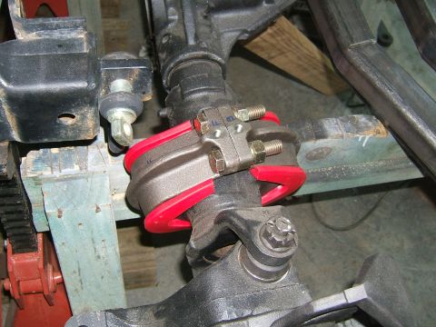 1993 Ford Bronco - Close-up view of a suspension component, likely part of an aftermarket upgrade, red urethane bushings.