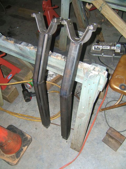 1993 Ford Bronco - Two custom-made metal parts are supported by wooden sawhorses in a workshop setting.