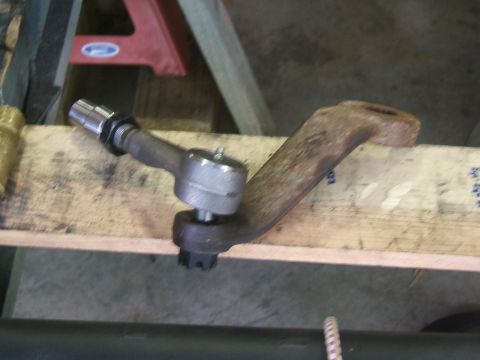 1993 Ford Bronco - A rusty steering linkage arm with a tie rod end is shown, likely a replacement part.