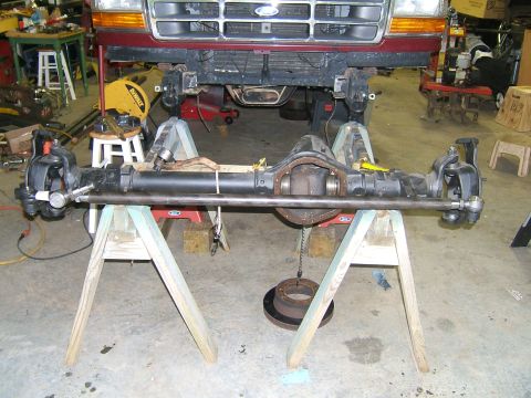 1993 Ford Bronco - The front axle assembly of a Ford truck is shown disassembled and supported on sawhorses.
