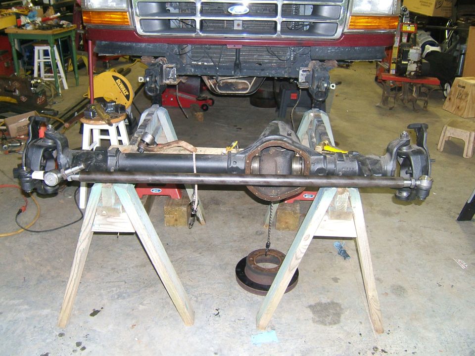 Front axle assembly of a 1993 Ford Bronco, supported by sawhorses in a garage