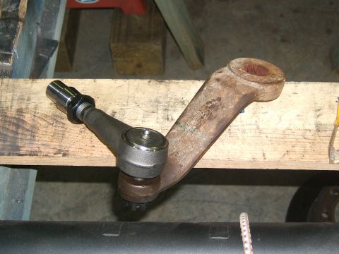 1993 Ford Bronco - A close-up view of a vehicle's steering linkage component, showing a rusty arm and tie rod end.