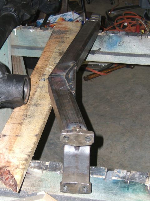 1993 Ford Bronco - A metal bracket with a bent shape is placed on a workbench with wooden planks.