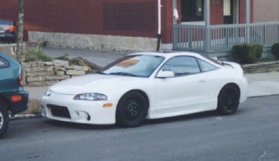 1997 Ford Taurus - it's kinda hard to tell, but he's got stock rims on the front, and aftermarket on the rear. also, he's got a hulkamania rules sticker on hi…