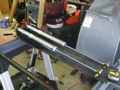 1993 Ford Bronco - Two Bilstein shock absorbers are shown mounted on a metal plate in a workshop setting.