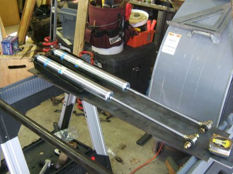 1993 Ford Bronco - Two new Bilstein shock absorbers are laid out on a workbench, ready for installation.