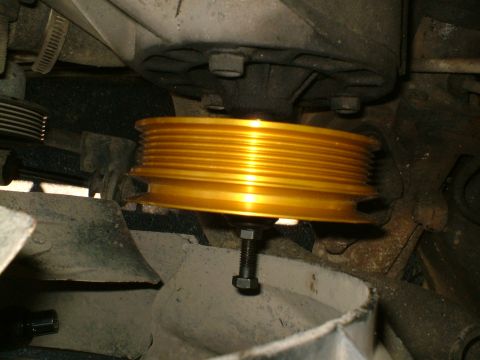 1989 Ford Bronco - A gold pulley with multiple grooves is shown mounted on an engine, likely part of an accessory installation.