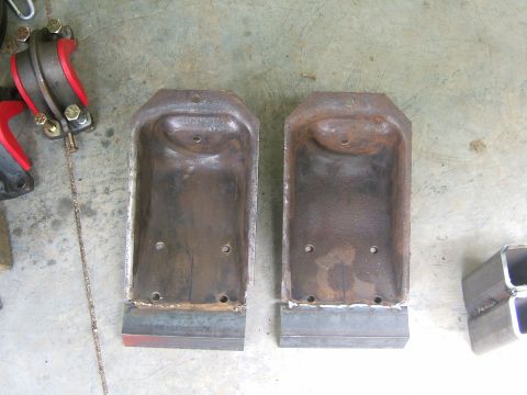 1993 Ford Bronco - Two metal brackets sit on a concrete surface next to some square tubing.