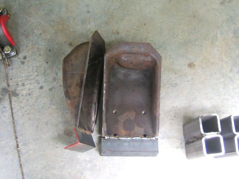 1993 Ford Bronco - Several metal parts, including brackets and tubing, are laid out on a concrete surface.