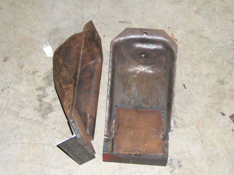 two rusted metal brackets on concrete floor