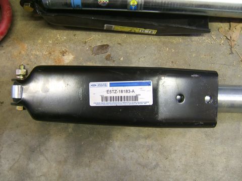 1993 Ford Bronco - A close-up shows a Ford Genuine Parts label on a black metal component, with a silver tube attached.