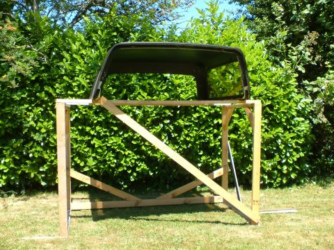 1989 Ford Bronco - Removed Ford Bronco hardtop resting on a custom wooden support structure in a yard.