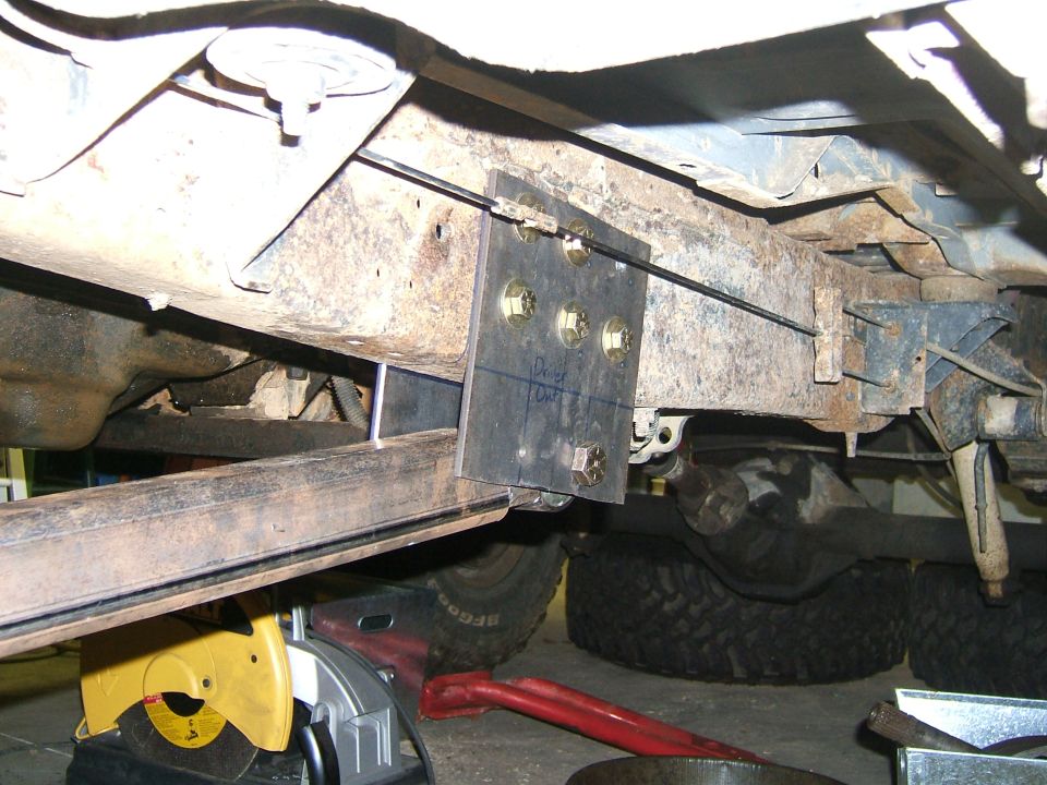 Modified frame with bracket and bolts, visible tire and suspension components