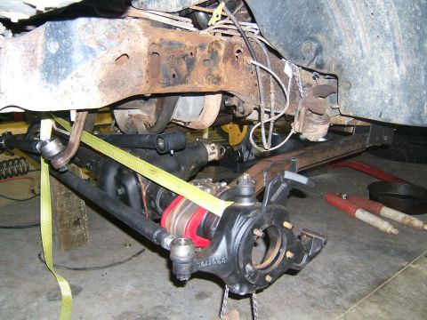 1993 Ford Bronco - The underside of a vehicle is shown, focusing on the suspension components and heavily rusted frame.