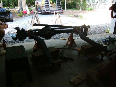 1993 Ford Bronco - A front axle assembly is supported by jack stands in a garage setting, indicating repair or modification work.