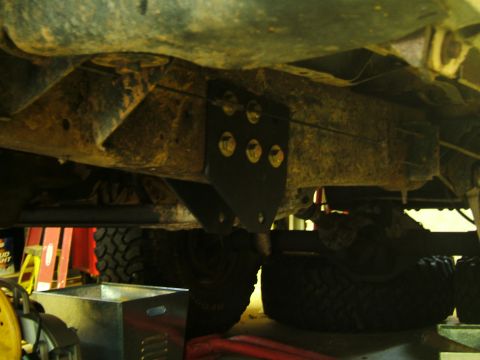 1993 Ford Bronco - This photo shows the underside of a vehicle, focusing on a newly installed bracket on the frame and suspension parts.