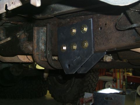 1993 Ford Bronco - Custom bracket installed on the undercarriage of a vehicle, with a large tire in view.