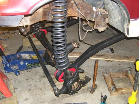 1993 Ford Bronco - Close-up of a vehicle's suspension system, showing springs, linkages, and a jack.