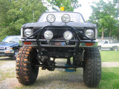 1992 Ford Mustang - This heavily modified Toyota pickup truck features large off-road tires and a custom brush guard. The "TOYOTA" badging is visible on the gr…
