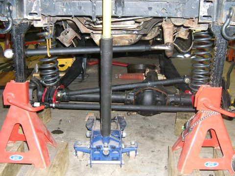 1993 Ford Bronco - Undercarriage view of a vehicle on jack stands, highlighting suspension and drivetrain components.