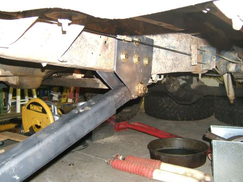 1993 Ford Bronco - Close-up view of a custom suspension bracket being installed on a vehicle's frame.