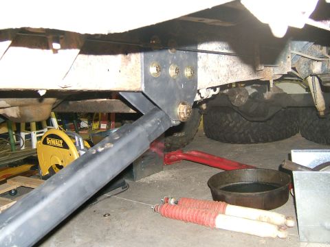 1993 Ford Bronco - Underbody view of a vehicle's suspension system with tools and parts nearby.