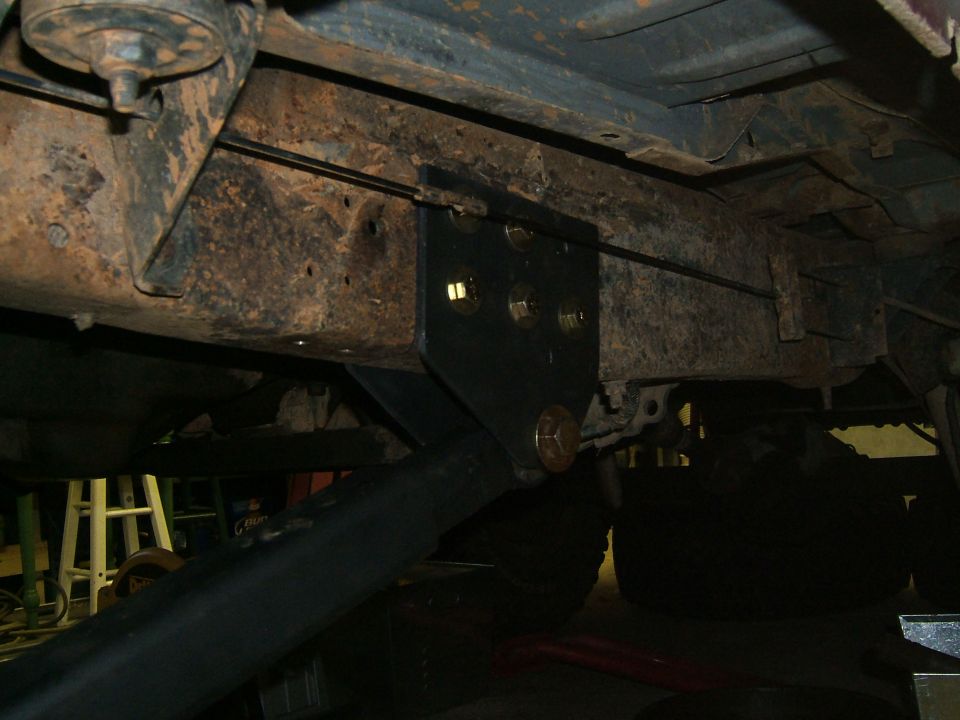 Underbody bracket bolted to rusty frame