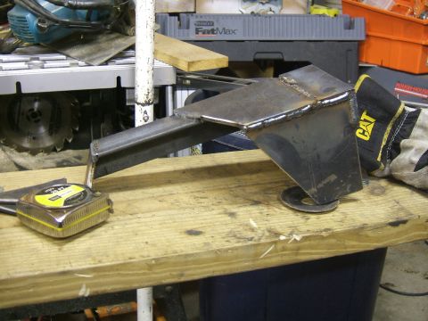 1993 Ford Bronco - A custom metal bracket sits on a workbench, alongside tools and a CAT work glove.