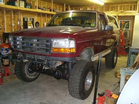 1993 Ford Bronco - This lifted 1993 Ford Bronco is parked in a garage, showing off its modified suspension and large tires.