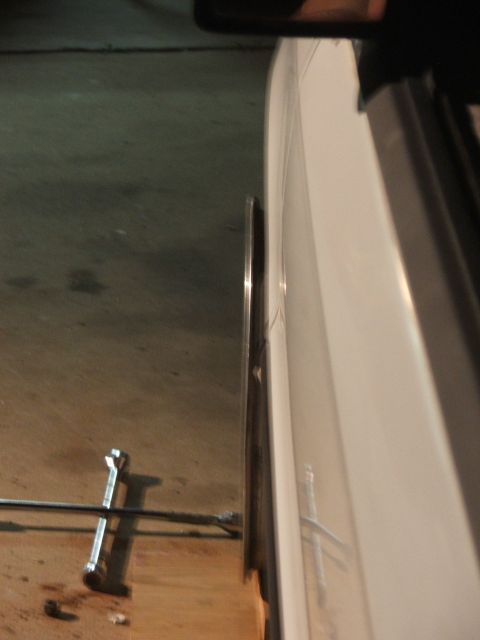 1990 Dodge Shadow - A close-up side view of a car's wheel and tire, with a lug wrench visible on the floor nearby.