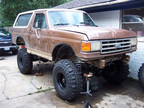 1987 Ford Bronco - This lifted Ford Bronco is undergoing modifications, with its front end raised on jack stands.