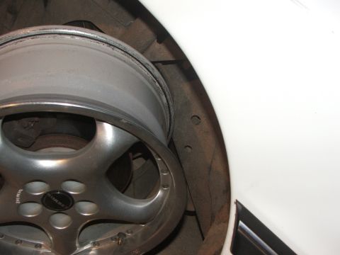 1990 Dodge Shadow - A close-up view of a Borbet wheel installed on a white vehicle, showing the wheel well and brake components.