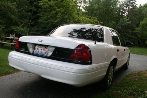 2003 Ford Crown Victoria - Rear view of a white 2003 Ford Crown Victoria, parked outdoors.