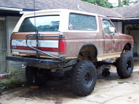 1987 Ford Bronco - This lifted 1987 Ford Bronco is shown from the rear, oversized tires and a custom bumper.