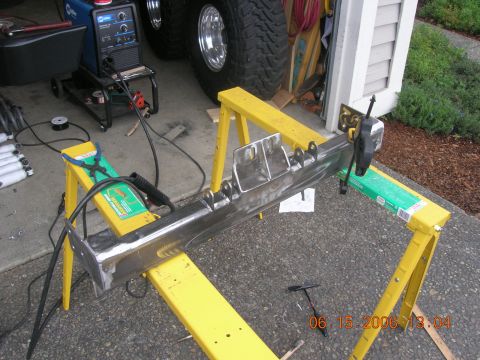 1996 Ford Bronco - Welding equipment and a custom metal part are set up on sawhorses in a driveway.
