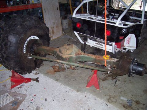 1989 Ford Bronco II - A rear axle assembly, likely from an off-road vehicle, is supported by red jack stands in a garage setting.